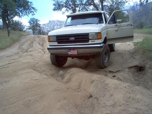 1988 Ford Bronco with driver's door open on a dirt road