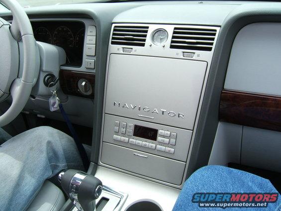 Interior shot of a Lincoln Navigator showing the center console with the 'NAVIGATOR' badge, climate controls, and gear shifter