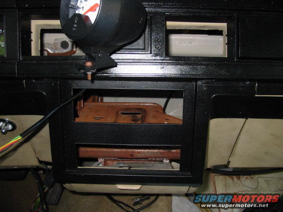 Dashboard interior of a 1985 Ford Crown Victoria LTD with a gauge mounted above the center console