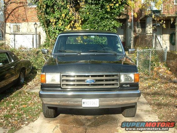 1989 Ford Bronco front view parked next to a dark coupe