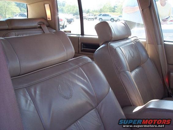 Leather seats inside a car, with a Cadillac emblem on the headrest