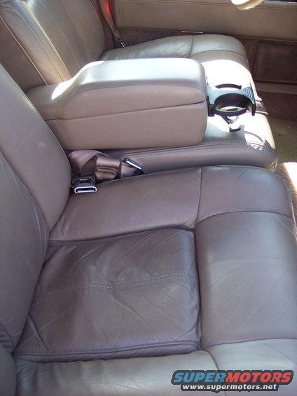 Tan leather front seats with center console and cup holder in a 1991 Cadillac DeVille