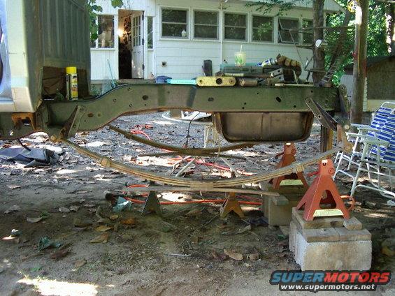 Truck frame and leaf springs on jack stands outdoors