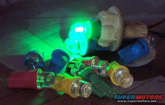 Various colored automotive bulbs, some lit green, with '12V DC' visible on one