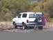 1993 Ford Bronco - This white SUV is parked off-road with an American flag attached to its spare tire.