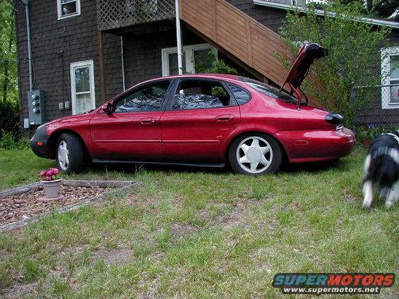 Red 1997 Ford Taurus sedan, side view, trunk open