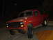 1981 Ford Bronco - A red 1981 Ford Bronco is parked outdoors at night.