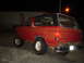 1981 Ford Bronco - Rear view of a red SUV with a black top and lifted suspension, parked outdoors at night.