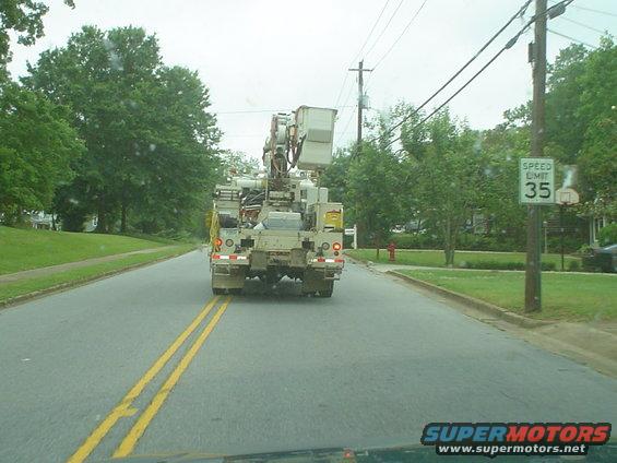 Bucket truck driving down a residential street