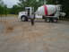 1981 Ford Bronco - A man stands in front of a white cement mixer truck parked on a gravel surface.