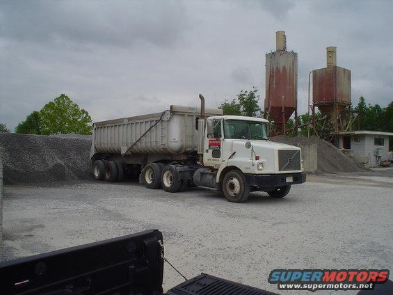 White Volvo dump truck and trailer at a gravel pit