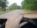 1981 Ford Bronco - Driving down a tree-lined road, the dashboard gauges are visible, including a 'FUEL' indicator.