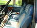 1981 Ford Bronco - The interior of a 1981 Ford Bronco shows blue seats and a heavily damaged dashboard.