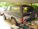 1981 Ford Bronco - This Ford Bronco is parked under a carport, carrying lumber on its roof. A second vehicle is visible to the left.