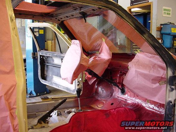 Interior of car with door open, covered in pink protective material