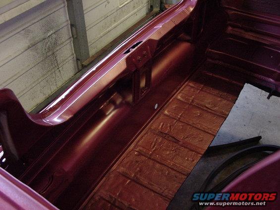 Maroon car interior showing the floor and side panel, with visible texture on the floor