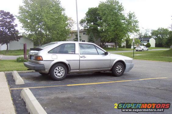 Silver 1983 Volkswagen Scirocco parked in a lot, another white car visible in the background