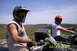 2003 Honda RUBICON - Two individuals enjoy a ride on their ATVs through a scenic, hilly landscape under a clear blue sky.