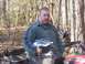 2003 Honda RUBICON - A man is seated on an all-terrain vehicle in a wooded area, holding a helmet.