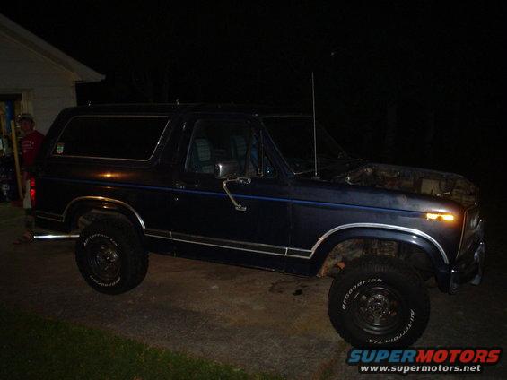 1981 Ford Bronco parked outside at night, hood up