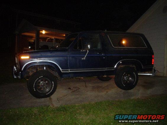 Blue Ford Bronco parked outside at night. Tires say BFGoodrich All-Terrain T/A
