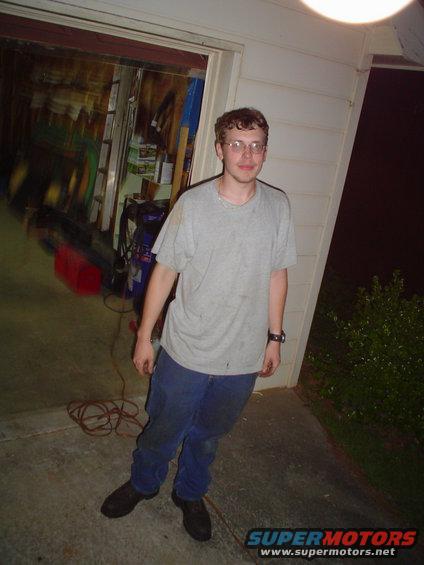 Man in t-shirt and jeans standing in front of an open garage door