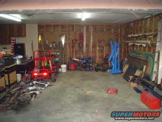 Garage interior with tools, engine parts, and a red go-kart
