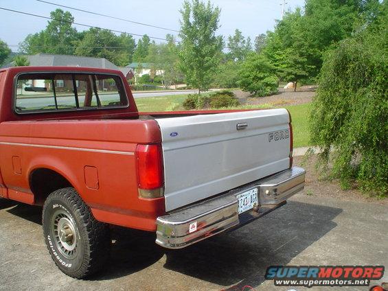 Rear view of a red and silver Ford pickup truck, license plate 243 NGR