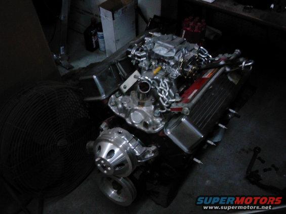 Chrome engine with carburetor and fan pulley, on a dark surface