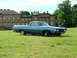1970 Ford Ranchero - A blue 1970 Ford Ranchero is parked on a green lawn with a large building in the background.