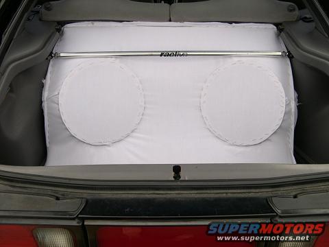 Trunk of a 1997 Ford Probe with a white subwoofer box and a silver strut bar labeled 'raptive'