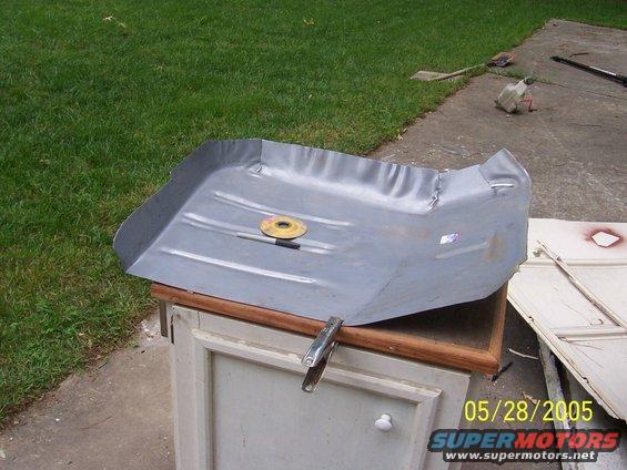 Gray car floor pan with a cutting disc on it