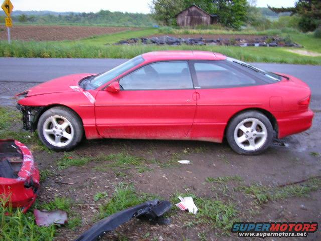 Red coupe with front damage, missing bumper and grille. Side view shows a two-door car with a sunroof