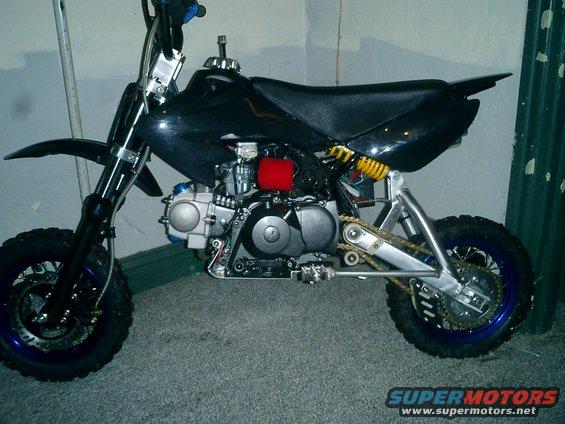 Black pit bike with blue rims and yellow rear shock