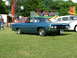 1970 Ford Ranchero - A blue 1970 Ford Ranchero is parked on a grassy field with a Ferris wheel and carnival attractions in the background.