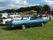 1970 Ford Ranchero - A blue 1970 Ford Ranchero is parked on a grassy field at an outdoor event, with a carousel and other vehicles visible.