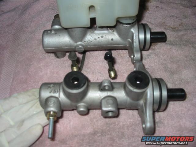 Two brake master cylinders, one with a plastic reservoir attached