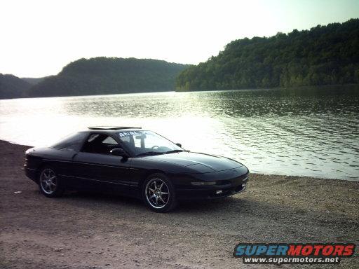 Black 1995 Ford Probe with sunroof parked by a lake
