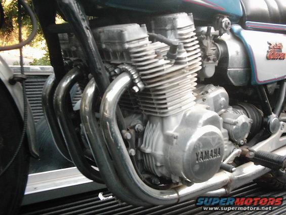 Motorcycle engine with four exhaust pipes and "YAMAHA" logo visible