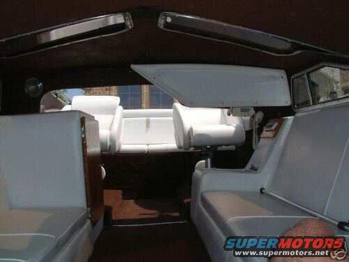 Boat interior with white upholstered seating and dark wood trim