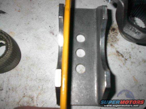 Metal bracket with three holes, a yellow pencil, and a splined connector part