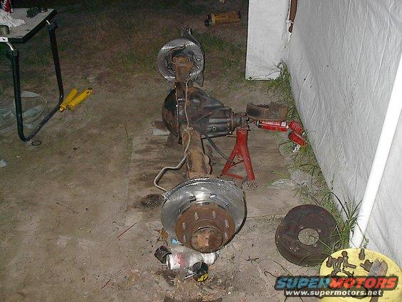 Rear axle assembly with brake rotors and calipers, on jack stands