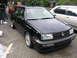 1994 Volkswagen Jetta - A black 1994 Volkswagen Jetta is parked on a driveway next to another vehicle, with a small shed in the background.