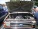 1979 Ford Bronco - Engine bay of a Ford truck, with another blue truck visible to the side.