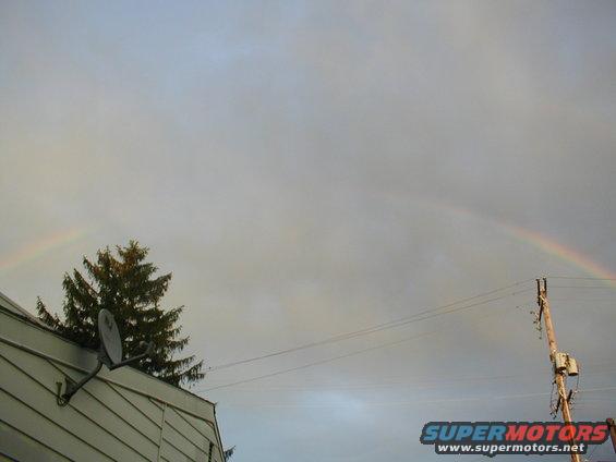 Rainbow over house and utility pole with Supermotors.net logo