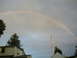 1979 Ford Bronco - A rainbow appears in the sky above houses and trees.