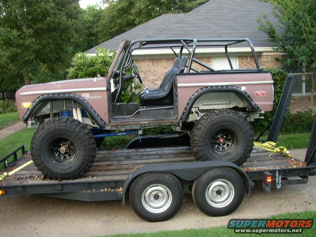 Brown 1974 Ford Bronco side view on trailer with roll cage