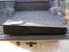 1999 Ford F-150 - A subwoofer box is placed in the bed of a pickup truck, which is equipped with a trailer hitch.