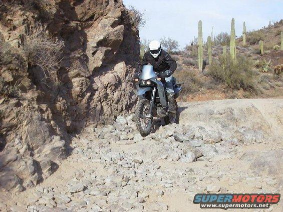 Motorcycle with a rider on a rocky desert trail