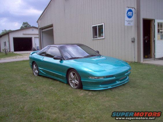 Teal 1993 Ford Probe coupe with black roof parked on grass